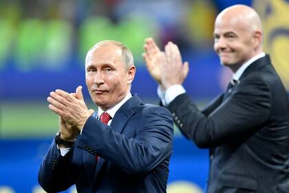El presidente ruso Vladimir Putin aplaude junto al presidente de la FIFA al término de la final de la Copa Mundial de Rusia 2018