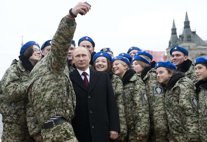 El presidente ruso Vladimir Putin posa para una selfie con jóvenes activistas en la Plaza Roja de Moscú