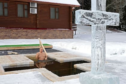 El presidente ruso, Vladimir Putin, se santigua mientras se sumerge en las aguas heladas durante la celebración de la fiesta de la Epifanía en la región de Moscú el 19 de enero de 2021