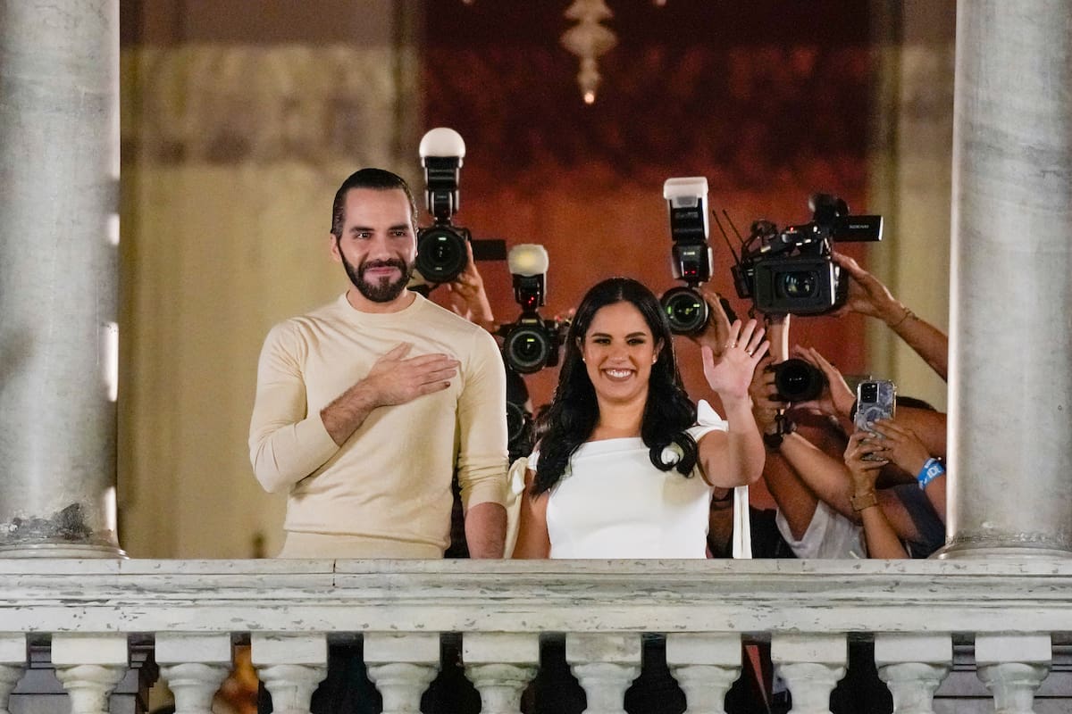 El presidente salvadoreño Nayib Bukele, izquierda, acompañado por su esposa Gabriela Rodríguez, saluda a sus seguidores desde el balcón del palacio presidencial tras el cierre de las urnas para las elecciones generales el domingo 4 de febrero de 2024, en San Salvador. (AP Foto/Moisés Castillo)