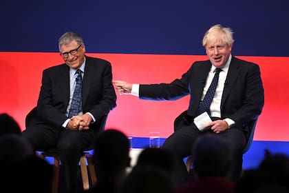 El primer ministro británico Boris Johnson, derecha, apareve en el escenario en conversación con el empresario estadounidense Bill Gates durante la Cumbre Global de Inversiones, Londres, martes 19 de octubre de 2021. (Leon Neal/Pool Foto via AP)