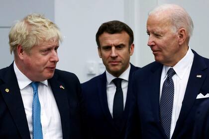El primer ministro británico Boris Johnson, a la izquierda; el presidente francés Emmanuel Macron, al centro, y el mandatario estadounidense Joe Biden llegan para la foto de grupo de los gobernantes del G7, durante una cumbre de la OTAN, el jueves 24 de marzo de 2022, en Bruselas. (Henry Nicholls/Foto compartida vía AP)