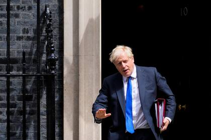 El primer ministro británico Boris Johnson lee un comunicado frente a su oficina en el número 10 de Downing Street, renunciando formalmente como líder del Partido Conservador, el jueves 7 de julio de 2022, en Londres. (Stefan Rousseau/PA vía AP)