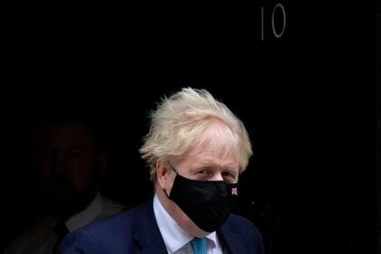 El primer ministro británico  Boris Johnson sale de la residencia de 10 Downing Street para dirigirse a la sesión semanal del Parlamento en la que responde a preguntas de los legisladores, miércoles 26 de enero de 2022. (AP Foto/Kirsty Wigglesworth)