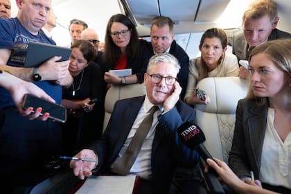 El primer ministro británico, Keir Starmer, habla con periodistas mientras viaja a bordo de un avión rumbo a Washington DC para asistir a una cumbre de la OTAN