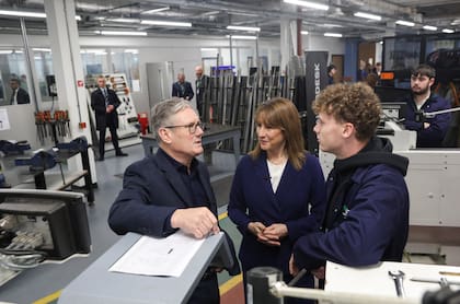 El primer ministro británico Keir Starmer habla con un estudiante al lado de la secretaria de Hacienda Rachel Reeves en Llangefni, Gales del Norte