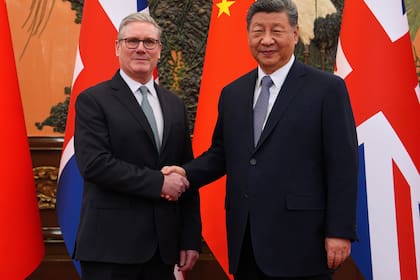 El primer ministro británico, Keir Starmer, se saluda con el presidente chino Xi Jinping en un encuentro bilateral en Pekín