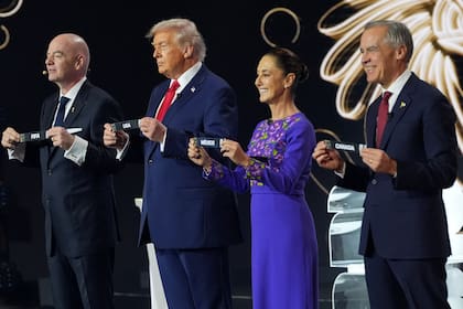 El primer ministro canadiense Mark Carney, la presidenta mexicana Claudia Sheinbaum, el presidente estadounidense Donald Trump y el presidente de la FIFA Gianni Infantino sostienen nombres de países en el sorteo de la Copa Mundial de Fútbol 2026 en el Kennedy Center de Washington, el viernes 5 de diciembre de 2025. (AP Foto/Jacquelyn Martin)