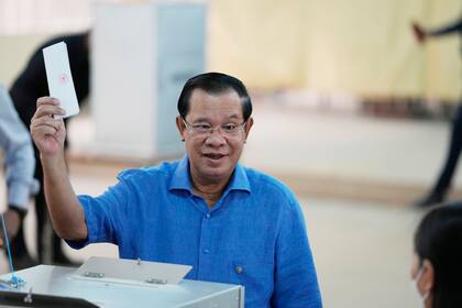 El primer ministro de Camboya Hun Sen sostiene su papeleta antes de meterla en una urna durante las elecciones del país, en Takhmua, Camboya, el domingo 5 de junio de 2022. (AP Foto/Heng Sinith, Archivo)