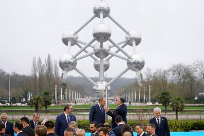 El primer ministro de Hungría, Viktor Orban, centro derecha, habla con el primer ministro polaco Donald Tusk, centro izquierda, luego de posar para una foro de grupo frente al Atomium durante la cumbre sobre energía nuclear, Bruselas, jueves 21 de marzo de 2024. (AP Foto/Virginia Mayo)