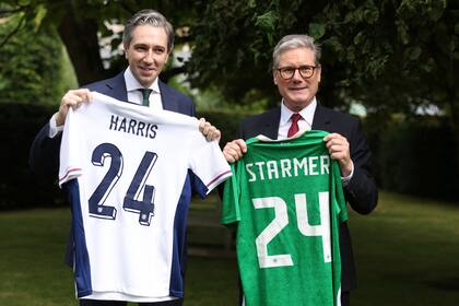 El primer ministro de Irlanda, Simon Harris, izquierda, y su homólogo británico, Keir Starmer, sostienen las camisetas de los equipos de fútbol de sus países, cada una con el nombre del otro, en Farmleigh House, en Dublín, Irlanda, el sábado 7 de septiembre de 2024. (AP Foto/Peter Morrison Pool)