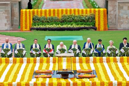 El primer ministro de la India, Narendra Modi (C), junto con líderes mundiales rinde respeto en el monumento a Mahatma Gandhi en Raj Ghat al margen de la cumbre del G20 en Nueva Delhi el 10 de septiembre de 2023. (Foto de PIB / AFP)