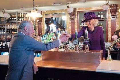 El príncipe de Gales y la duquesa de Cornwall, a pleno brindis en un pub londinense.