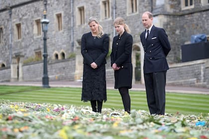 El príncipe Eduardo, conde de Wessex, su esposa Sofía, condesa de Wessex, y su hija, Lady Louise Windsor, contemplan las flores en el exterior de la capilla de San Jorge, en el castillo de Windsor, al oeste de Londres.