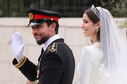 El príncipe heredero de Jordania, Hussein, y su esposa saudita Rajwa al-Seif se marchan en un convoy después de su ceremonia de boda real en Amán el 1 de junio de 2023.
