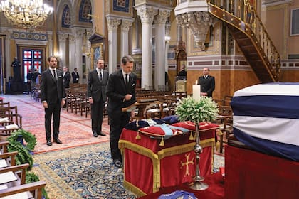 El príncipe heredero Pablo junto a sus hermanos, los príncipes Philippos y Nicolás, le rinde honores a su padre.