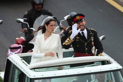 El príncipe Hussein y la saudita Rajqa Alseif saludan a la gente a su paso hacia el lugar de la ceremonia