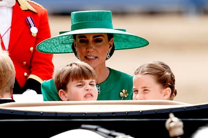 El Príncipe Luis, Kate, la Princesa de Gales y la Princesa Charlotte viajan en un carruaje mientras participan en la Procesión Real cuando regresa al Palacio de Buckingham después del desfile Trooping the Color en junio de 2023