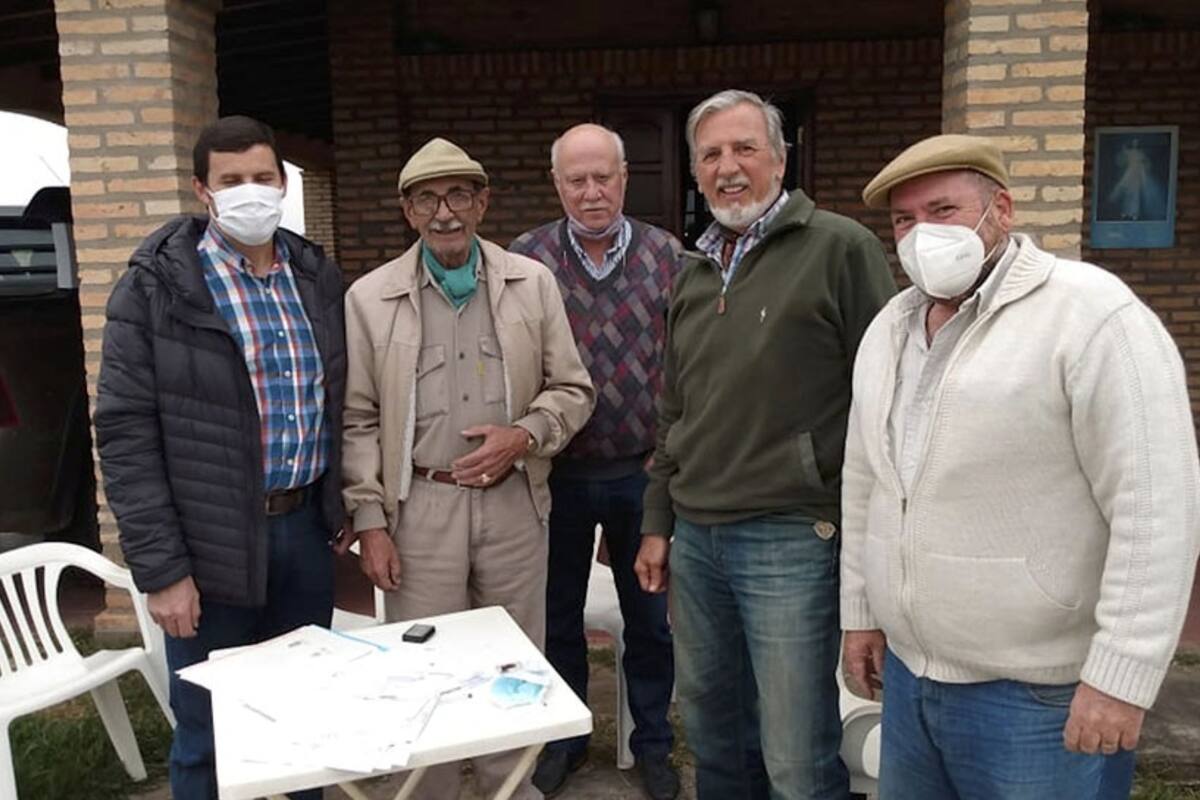 El productor ganadero Félix Silva (de boina y pañuelo verde) junto a personal del INTA en el momento en que firmó la donación de las 508 hectáreas de su campo en favor del instituto