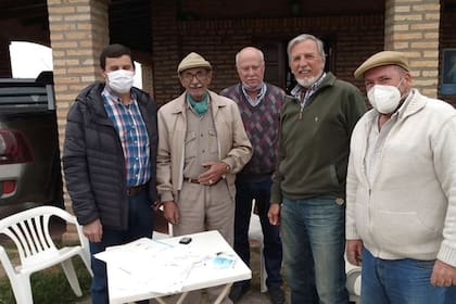 El productor ganadero Félix Silva (de boina y pañuelo verde) junto a personal del INTA en el momento en que firmó la donación de las 508 hectáreas de su campo en favor del instituto