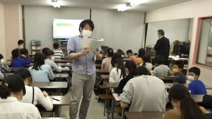 El profesor dicta con rapidez los números a sumar. Los estudiantes hacen cuentas con el ábaco en cuestión de segundos.