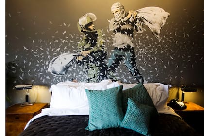 Una pintura de Banksy de la policía de frontera israelí y un palestino en una lucha de almohada sobre la cama de una de las habitaciones