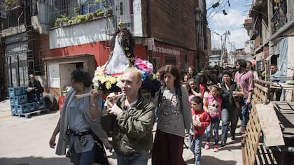 El público participa de una procesión religiosa en la calle, como parte de la obra