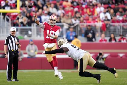 El quarterback de los 49ers de San Francisco Jimmy Garoppolo (10) lanza el balón mientras lo intenta capturar el defensive end Malcolm Roach en el encuentro del domingo 27 de noviembre del 2022. (AP Foto/Godofredo A. Vásquez)