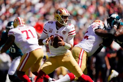 El quarterback de los 49ers de San Francisco Jimmy Garoppolo observa antes de lanzar el balón en la primera mitad del encuentro ante los Eagles de Filadelfia el domingo 19 de septiembre del 2021. (AP Photo/Matt Slocum)