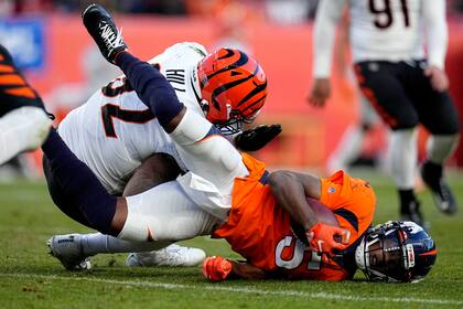El quarterback Teddy Bridgewater (5), de los Broncos de Denver, recibe un golpe del defensive end B.J. Hill, de los Bengals de Cincinnati, en partido del domingo 19 de diciembre de 2021, en Denver. Bridgwater abandonó el partido tras resultar lesionado en la jugada. (AP Foto/Jack Dempsey)