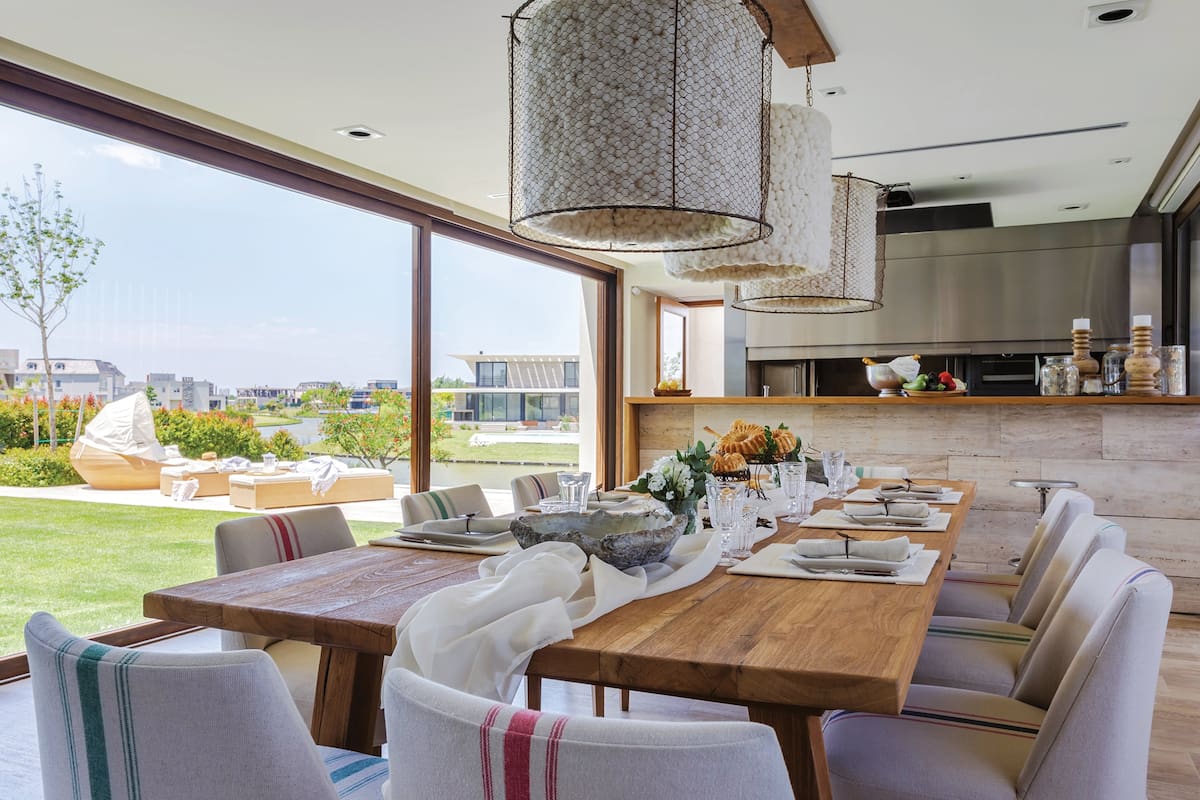 El quincho fue ambientado con una mesa de petiribí, diseñada por la dueña de casa al igual que las lámparas de lana de oveja y hierro color óxido. Acompañan un juego de sillas y sillón (Estudio LGP Interiorismo).