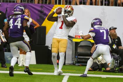 El receptor de los 49ers de San Francisco Deebo Samuel Sr. atrapa un pase ante el safety Josh Metellus y cornerback Byron Murphy Jr. de los Vikings de Minnesota el domingo 15 de septiembre del 2024. (AP Foto/Bruce Kluckhohn)