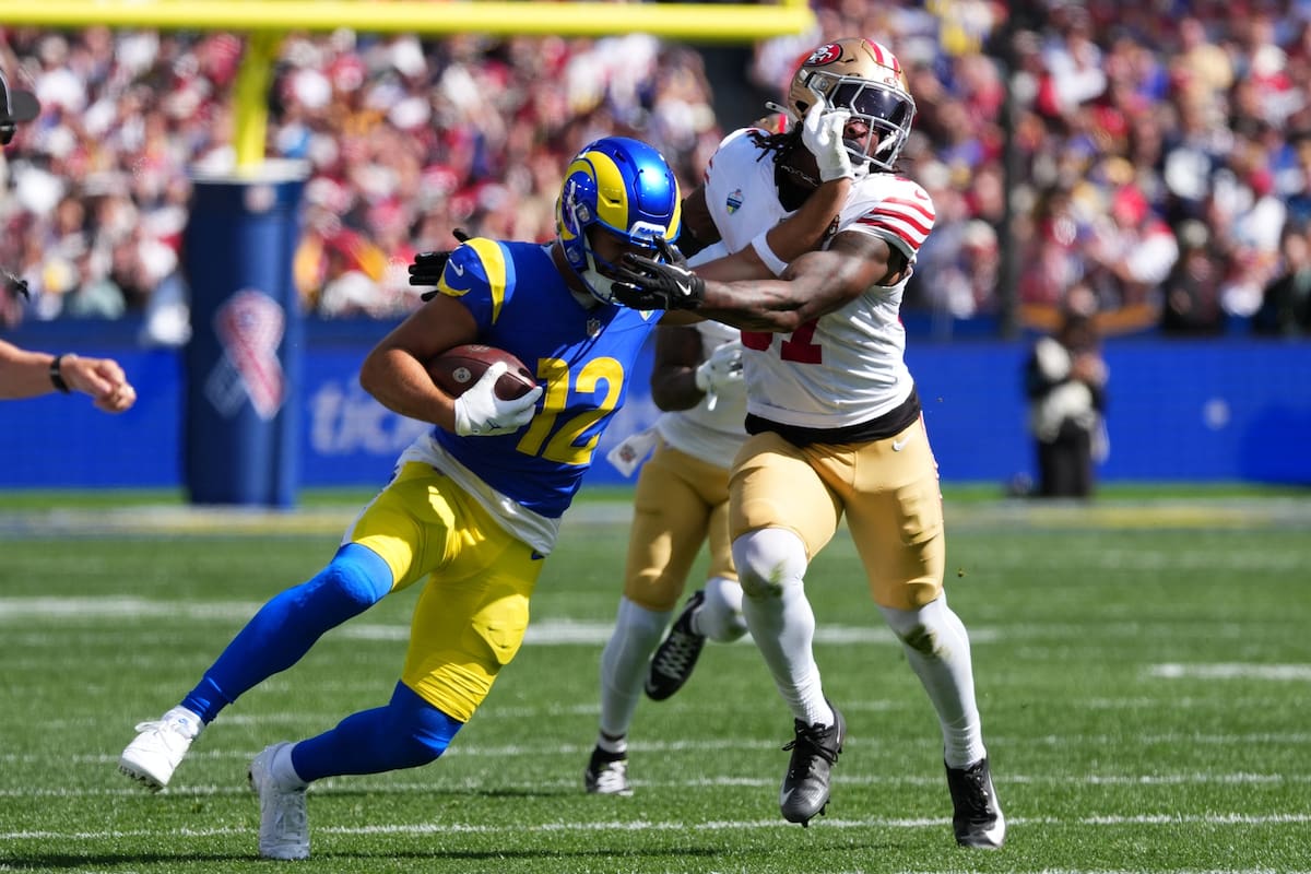 El receptor de los 49ers de San Francisco Puka Nacua corre con el balón frente al safety de los 49er