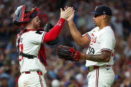 El receptor de los Mellizos de Minnesota, Ryan Jeffers, a la izquierda, y el lanzador relevista Jhoan Duran, a la derecha, celebran después de su victoria sobre los Medias Blancas de Chicago el sábado 3 de agosto de 2024, en Minneapolis. (AP Foto/Matt Krohn)