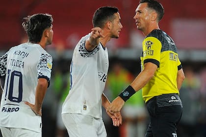 El reclamo de Marcone a Dóvalo; el volante recibió un patadón de Domínguez, pero el árbitro sólo amonestó al jugador de Barracas Central