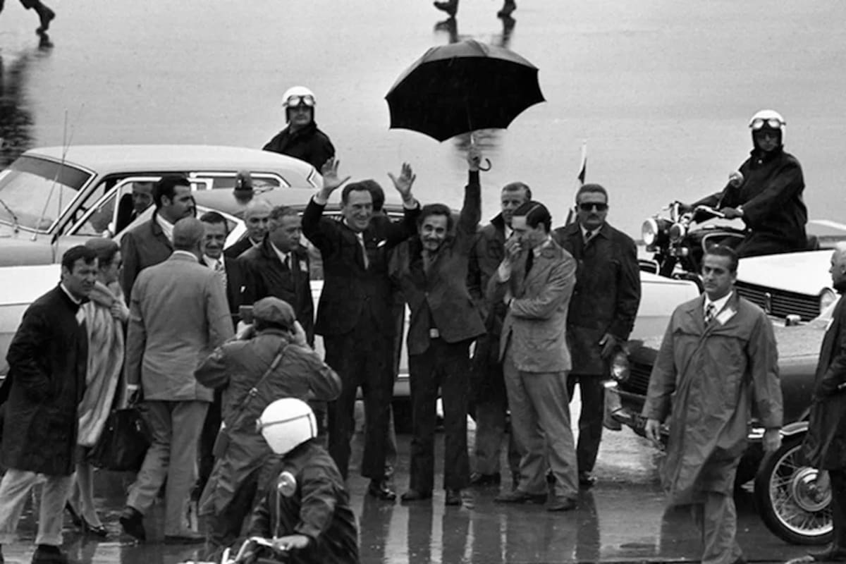 El regreso a la Argentina de Juan Domingo Perón del 17 de noviembre de 1972. Perón alza los brazos, José Ignacio Rucci levanta su paraguas y Juan Manuel Abal Medina, pensativo, se toca la cara.