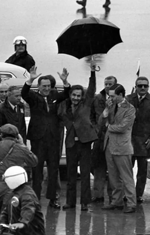 El regreso a la Argentina de Juan Domingo Perón del 17 de noviembre de 1972. Perón alza los brazos, José Ignacio Rucci levanta su paraguas y Juan Manuel Abal Medina, pensativo, se toca la cara.