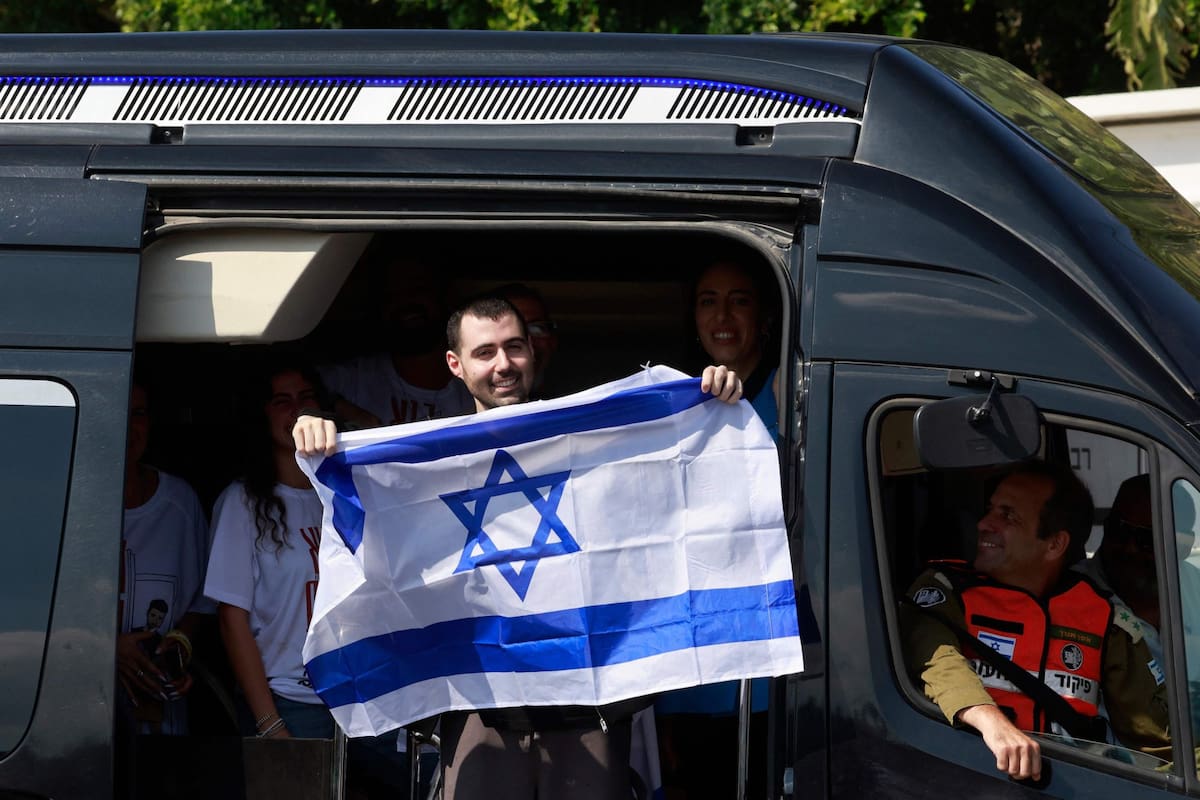 El rehén israelí liberado, Guy Gilboa Dalal, ondea la bandera israelí a su llegada al Hospital Beilinson del Centro Médico Rabin en Petah Tikva, en el centro de Israel, el 13 de octubre de 2025