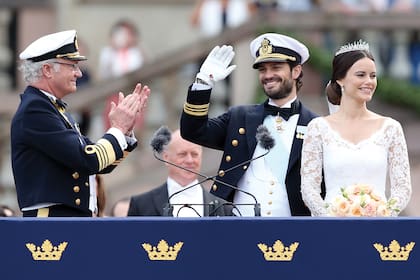 El rey Carlos Gustavo aplaude a su hijo, el príncipe Felipe, tras su boda con Sofía Hellqvist