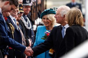 El rey Carlos III de Gran Bretaña estrecha la mano junto a Camilla, reina consorte de Gran Bretaña y el embajador británico en Alemania Jill Gallard después de aterrizar en el aeropuerto de Berlín Brandenburgo en Schoenefeld, cerca de Berlín, el 29 de marzo de 2023