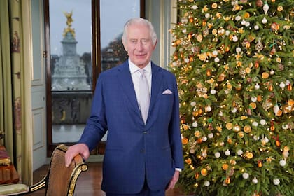 El rey Carlos III de Gran Bretaña posa durante la grabación de su mensaje navideño en el Palacio de Buckingham, Londres