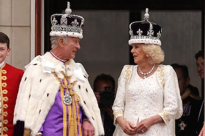 El rey Carlos III habla con la reina Camilla en los balcones del Palacio de Buckingham