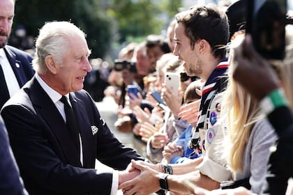 El rey Carlos III saluda a miembros del público que esperan para ingresar a Westminster Hall