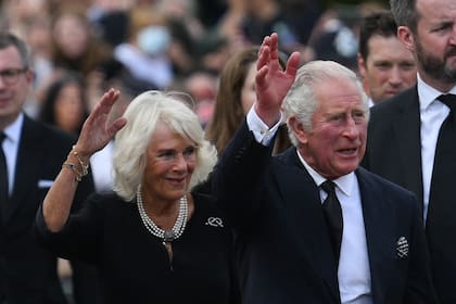 El rey Carlos III y Camilla, la reina consorte, saludan a la multitud a su llegada al Palacio de Buckingham
