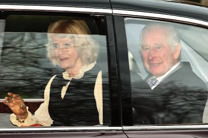 El rey Carlos III y su esposa Camilla, saludan el martes a su salida de Clarence House (Photo by HENRY NICHOLLS/AFP via Getty Images)