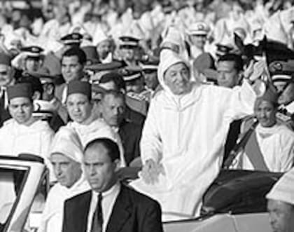 El rey Hassan II saluda a la multitud en un desfile con motivo del 36° aniversario de su asunción al trono, en marzo de 1997