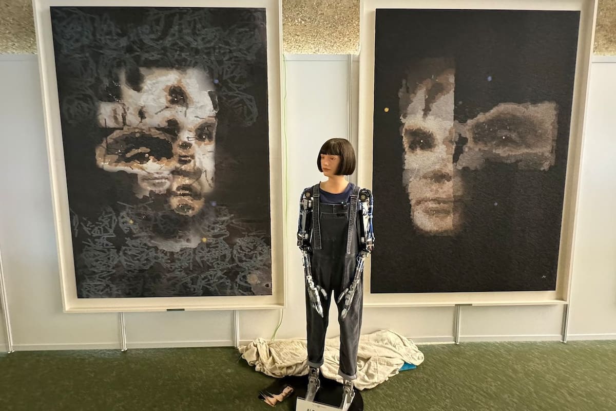 El robot artista Ai-Da junto a sus retratos de Alan Turing; el de la derecha será subastado por Sotheby's a fin de octubre