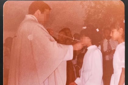 El sacerdote D. A. M. M., apartado de una parroquia de Vicálvaro tras una acusación de abusos de menores de una mujer, en una imagen en la que aparece con la denunciante cuando era niña el día de su primera comunión en 1983, en Mendoza, Argentina