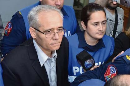 El sacerdote Justo José Ilarraz ingresa en la sala de audiciencia custodiado por la policía