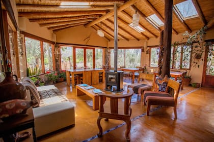 El salón-comedor, con salamandra y ventanales con vista a la cordillera.